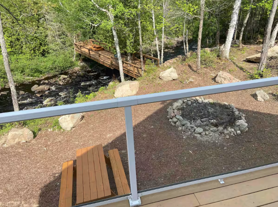 View from the second floor deck overlooking fireplace, deck, and river